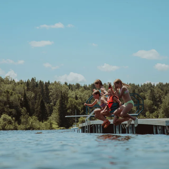 Enfants sautant dans le lac à l'Éco-Parc des Etchemins à Lac-Etchemin