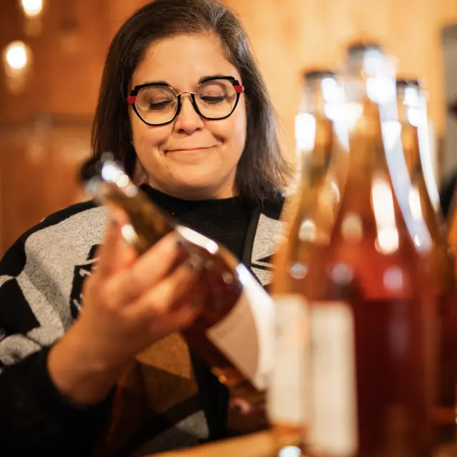 Femme qui regarde bouteille de cidre au Domaine Ritt à Cap-Saint-Ignace