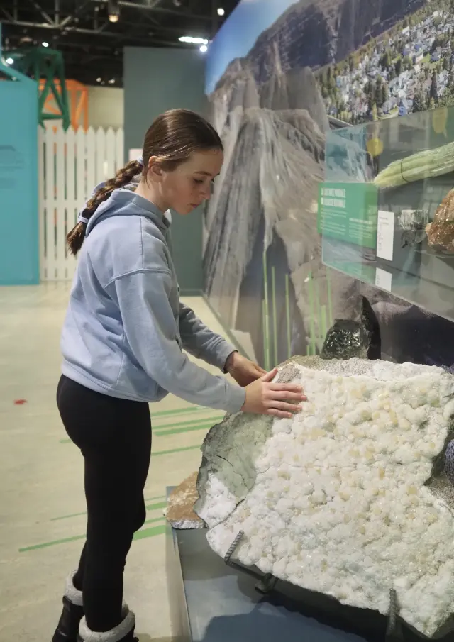 Jeune fille découvrant les minéraux de l'exposition permanente du Musée Minéro à Thetford Mines