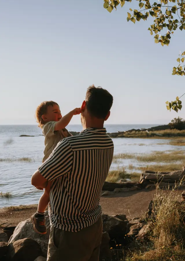 Père et enfant appréciant la vue sur le fleuve au Camping et chalets de la Demi-Lieue à Saint-Jean-Port-Joli