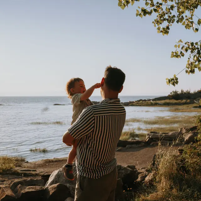 Père et enfant appréciant la vue sur le fleuve au Camping et chalets de la Demi-Lieue à Saint-Jean-Port-Joli