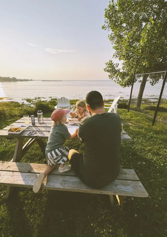 Famille dégustant un repas sur une table à pique-nique au Motel La Plage
