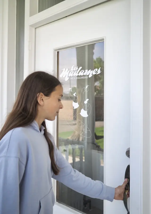Jeune fille à l'entrée de chez Les Madames Café & Boulangerie à Saint-Bernard