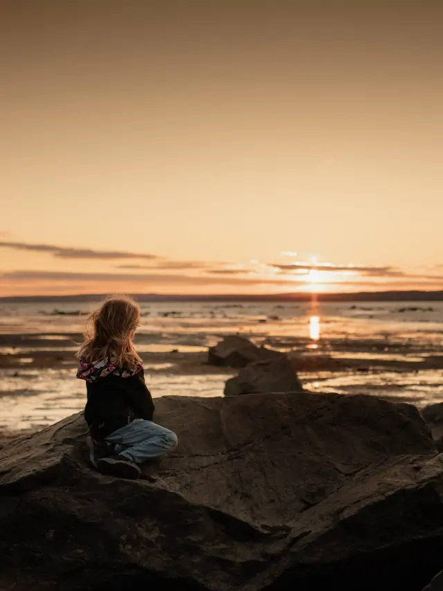 Enfant contemplant le coucher de soleil à l'Anse Ross, Anse Ross | Lévis